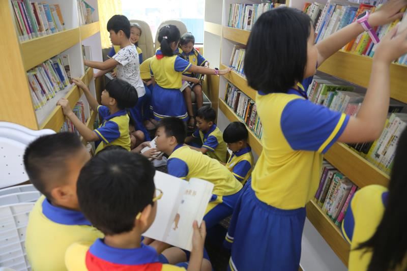 孩子们在图书车里认真翻阅图书