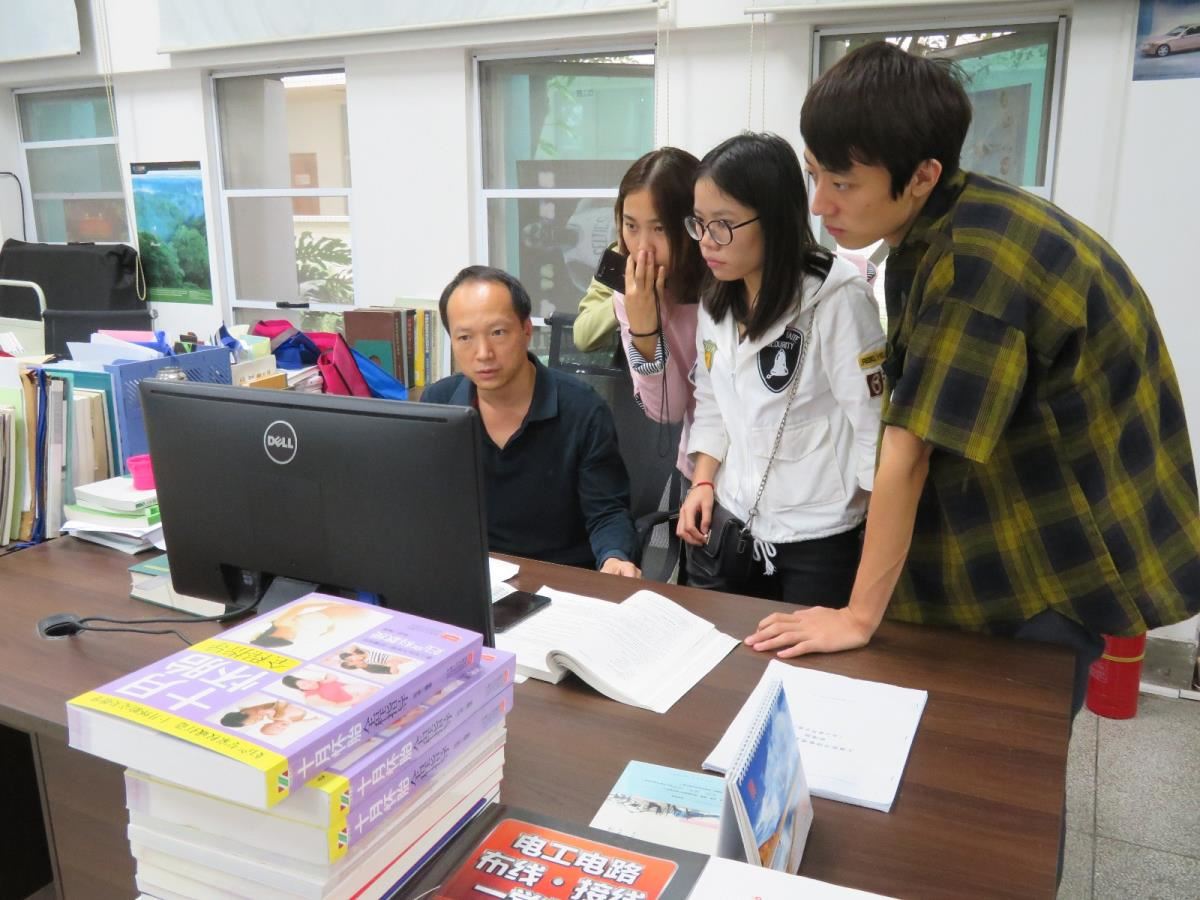 学生在采编中心与工作人员交流
