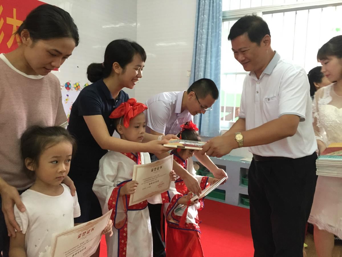 3.岑志坚主任向榜样阅读家庭颁发奖状和绘本