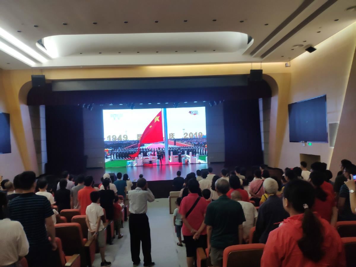 报告厅现场读者齐唱国歌