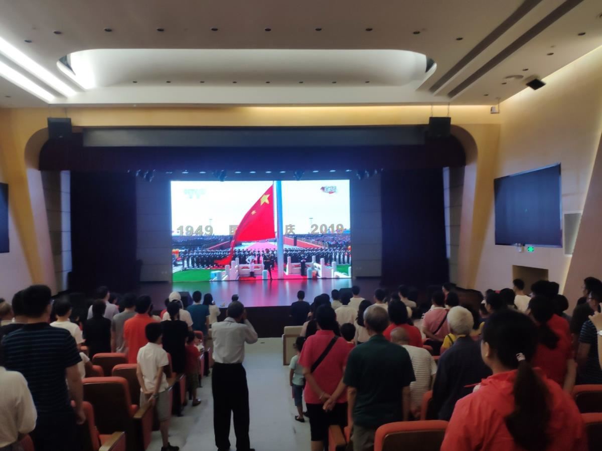 报告厅现场读者齐唱国歌