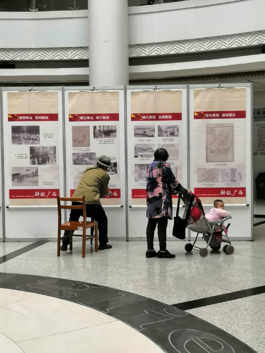 老读者坐着椅子细细观展